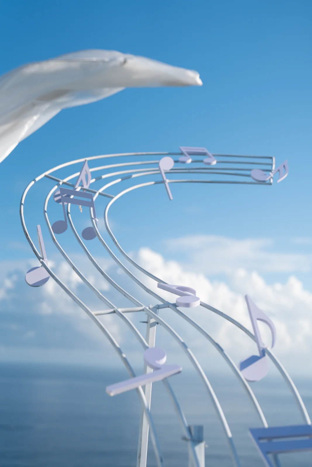 Musical-note wedding decoration and flowing white fabric against the sky and ocean